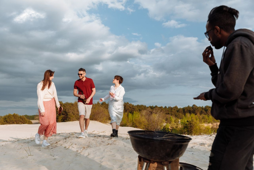 Gruppe mit Grill am Sandstrand